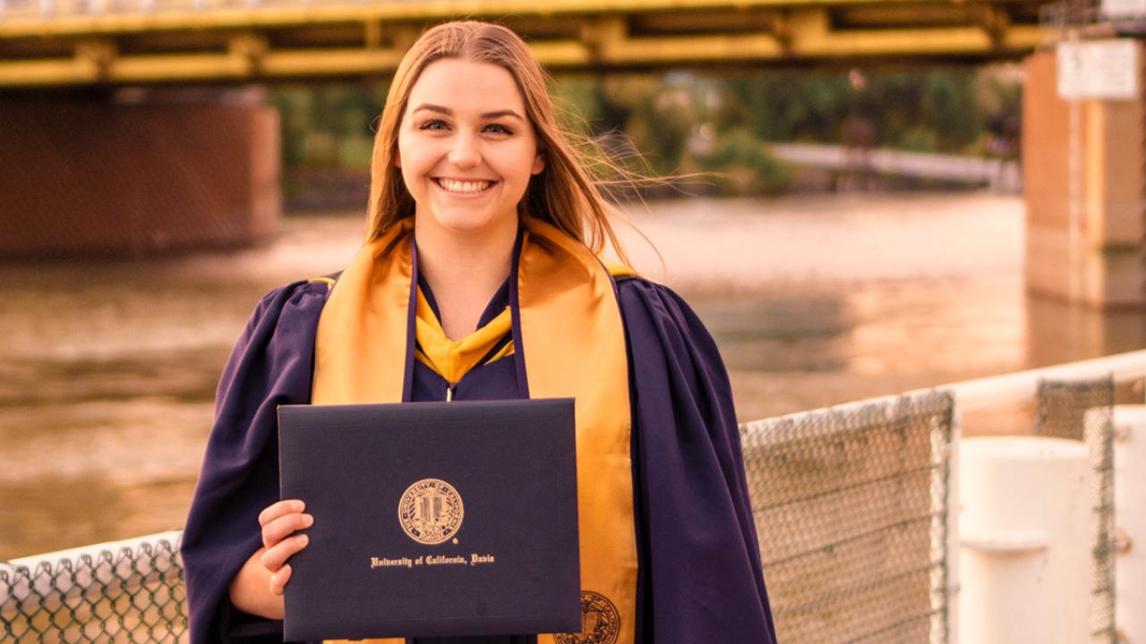 UC Davis Forensic Science master's grad Emily Helmes poses in her cap and gown