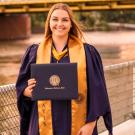 UC Davis Forensic Science master's grad Emily Helmes poses in her cap and gown