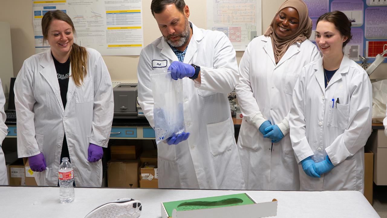UC Davis Forensic Science lecturer Philip Hess and students look at footwear tracks