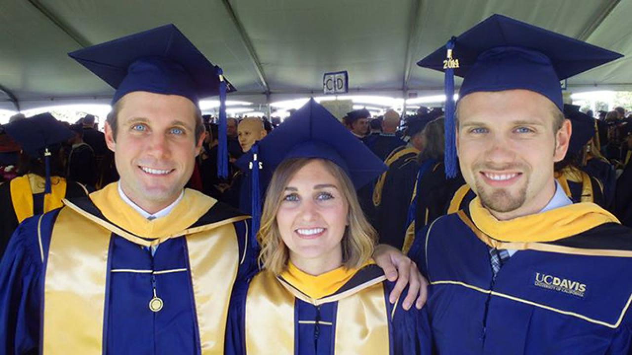 UC Davis Forensic Science graduate Shane Williams and fellow alumni in cap and gown at graduation